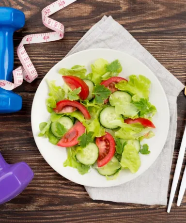 Ensalada junto a mancuernas y una manzana