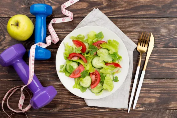 Ensalada junto a mancuernas y una manzana